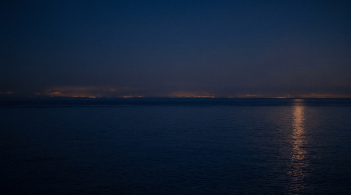 An ocean liner mid-Atlantic at dusk beneath a golden sky